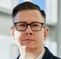 Alexander Hughes retratado como CEO de una empresa de trading de criptomonedas